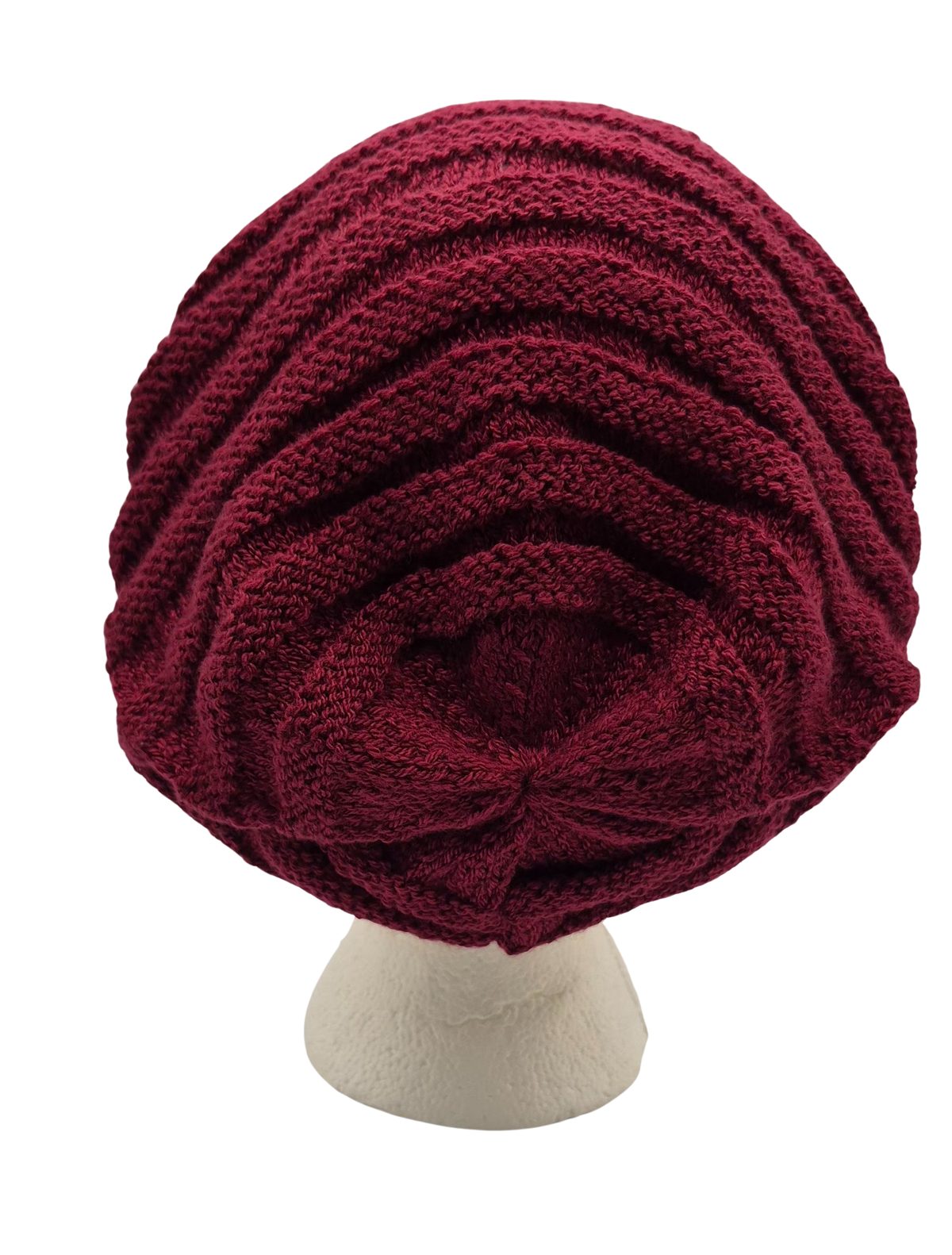 A chunky knit slouchy beanie hat in deep burgundy, displayed on a textured off-white mannequin head.