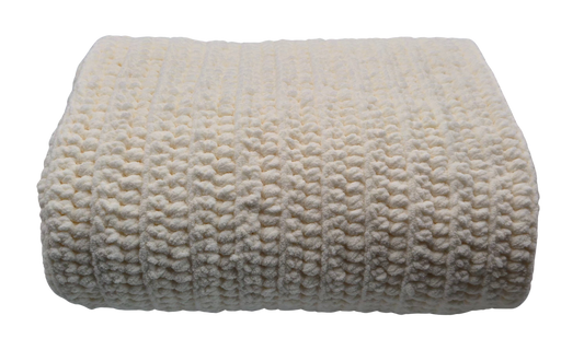 A folded cream-colored chunky crocheted baby blanket with a textured bumpy stitch pattern.