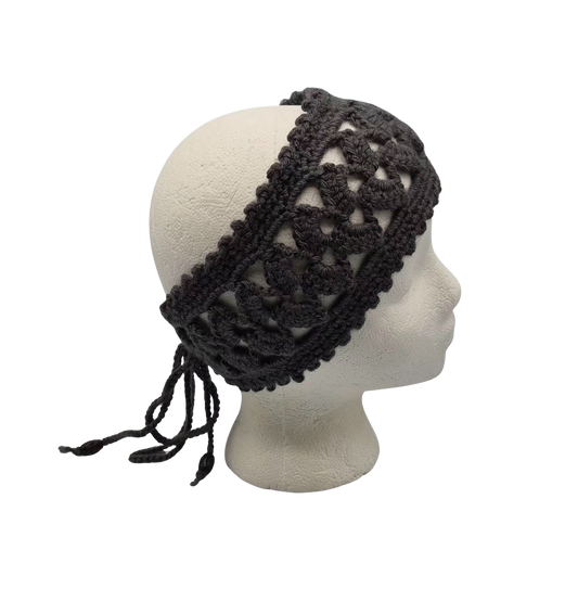 A dark charcoal gray crocheted headband with a large openwork pattern and tie strings, displayed on a white mannequin head.