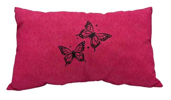 A rectangular pink throw pillow with a textured fabric surface, featuring two black vinyl butterflies and small star accents on the front.