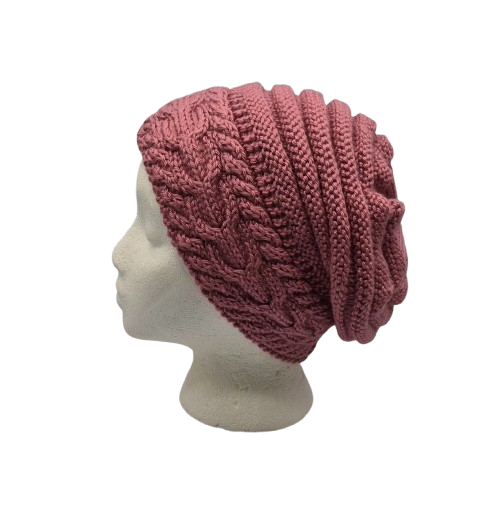 A dusty rose cable-knit slouchy beanie hat displayed on a white mannequin head.