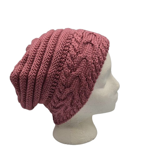 A dusty rose chunky knit slouchy beanie hat with cable and ribbed patterns, displayed on a white mannequin head.